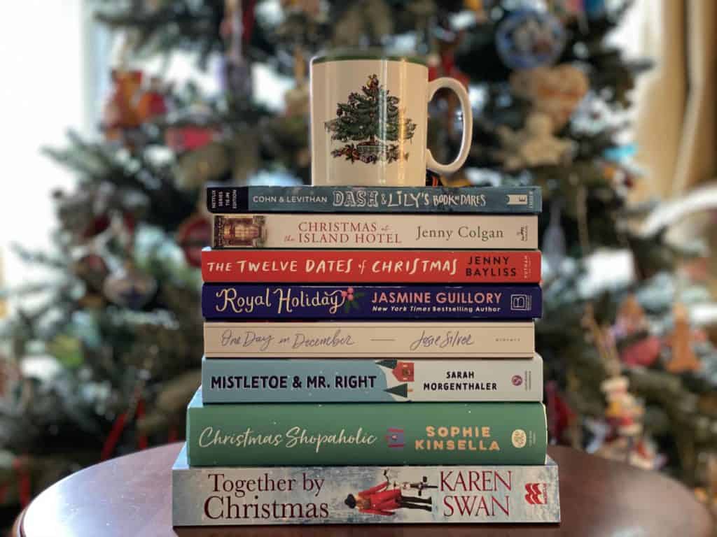 stack christmas books on table with christmas mug on top