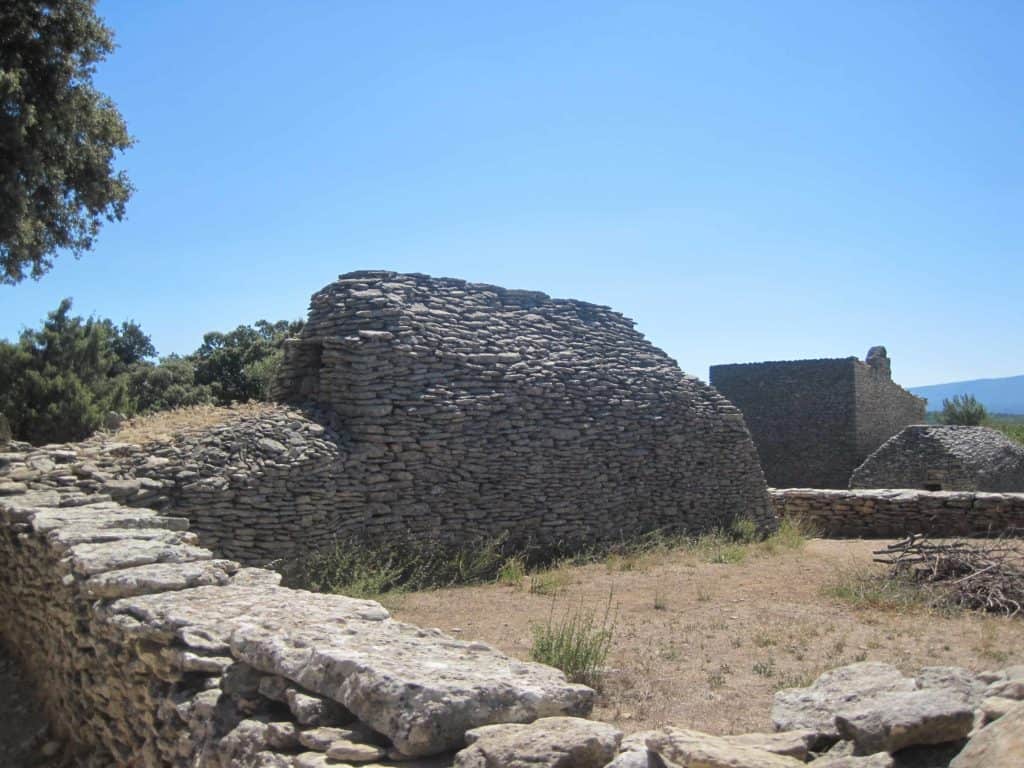 Borie structures at Village des Bories with bright blue sky.