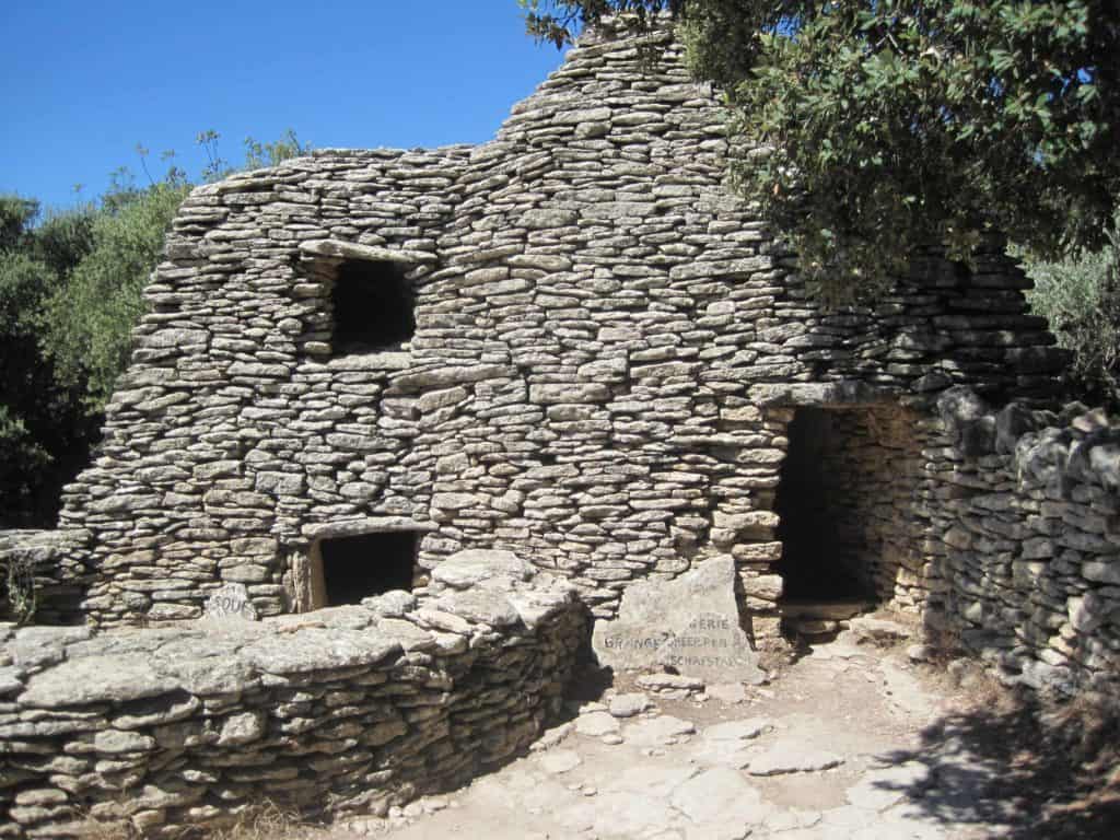 Borie structure with entrance door and two window spaces in stones.