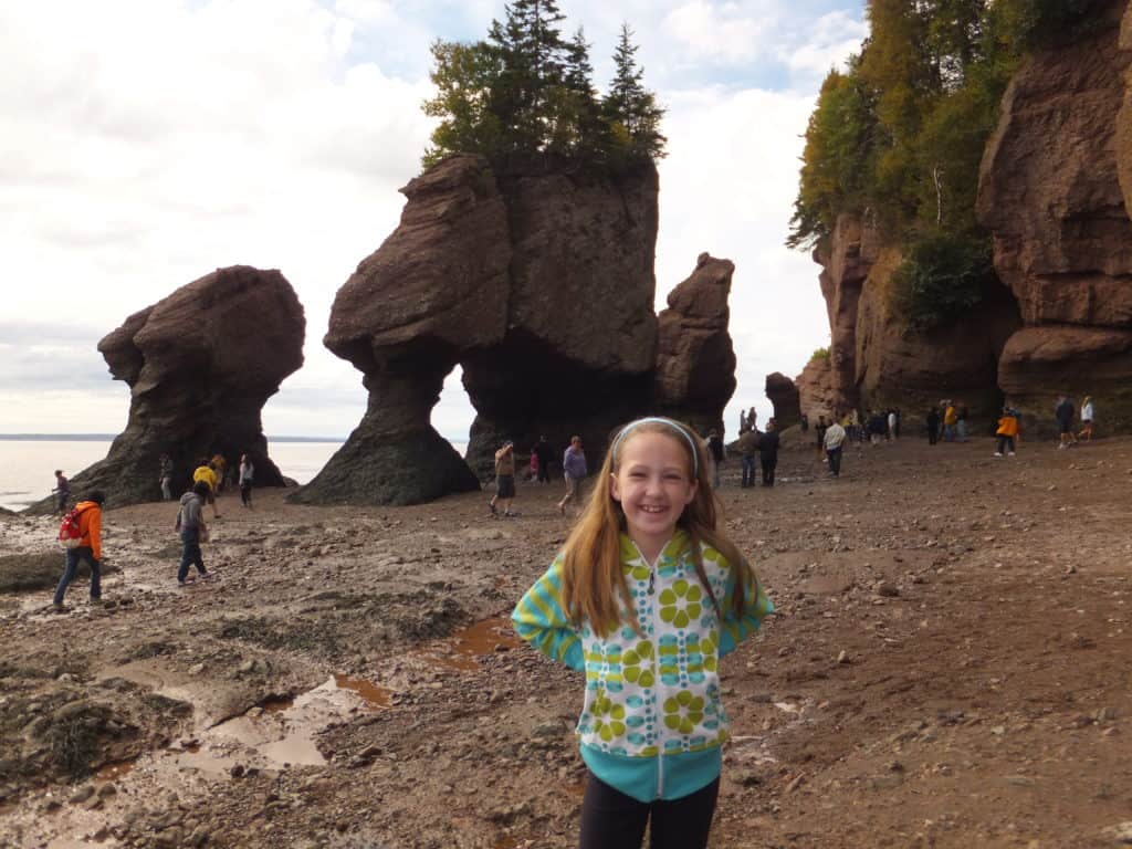 young girl walking on ocean floor at low tide at hopewell rocks in the bay of fundy, new brunswick.