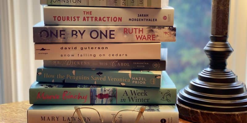 stack of books on table by lamp