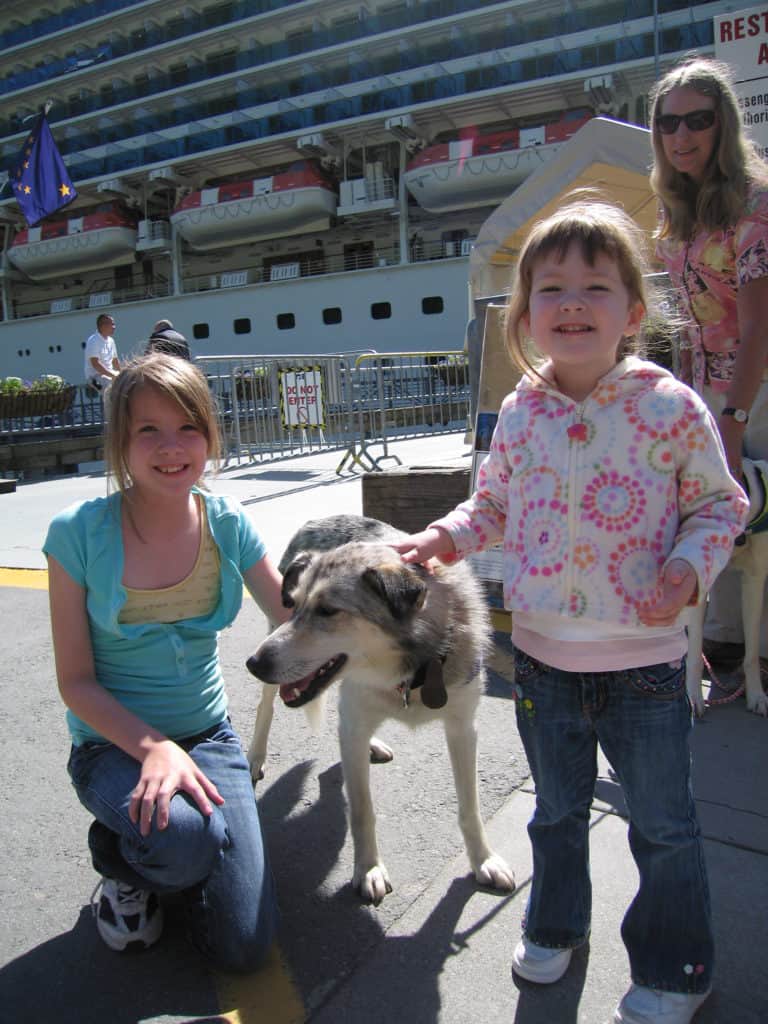 juneau-alaska-two girls with sled dog and Libby Riddles-cruise ship in background