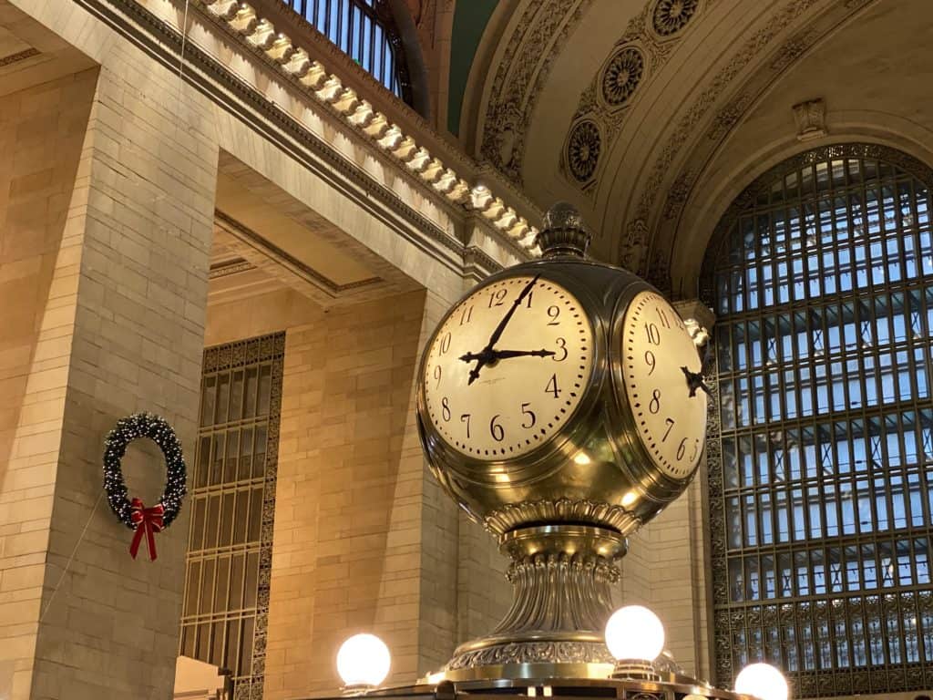 Clock in Grand Central Terminal with Christmas wreath on wall.