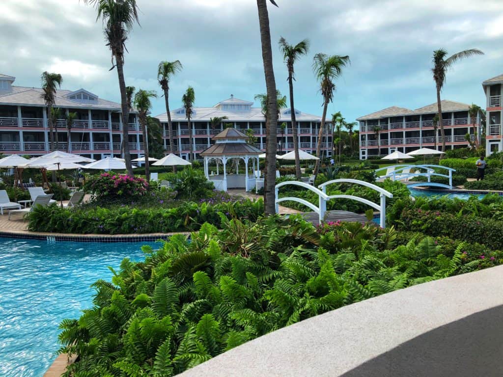 Ocean Club Resorts in Turks & caicos - pool, shrubbery, umbrellas and chairs with resort buildings in background.
