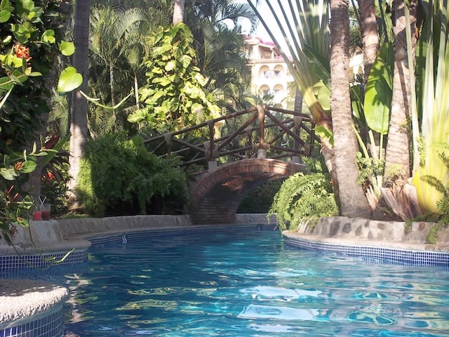 Curving pool with bridge and trees at Velas Vallarta, Puerto Vallarta, Mexico.
