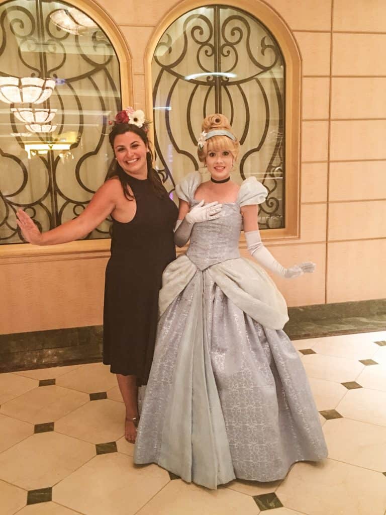 Woman posing with Cinderella on Disney cruise ship.