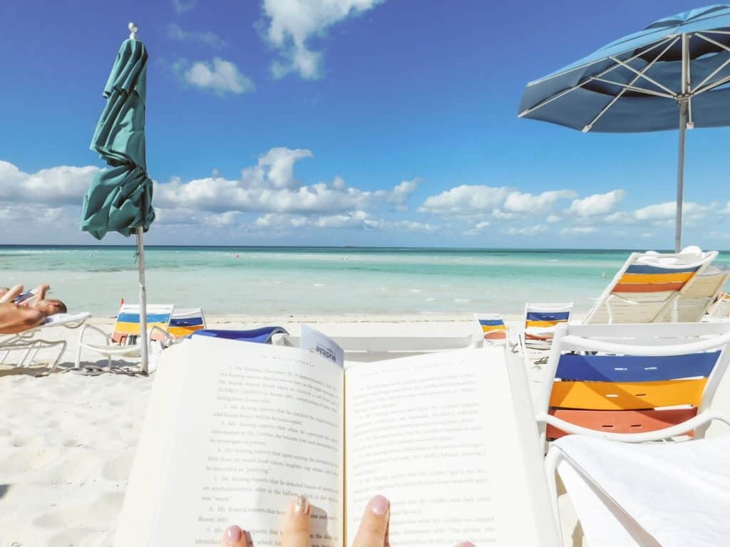 Woman reading book on the beach.