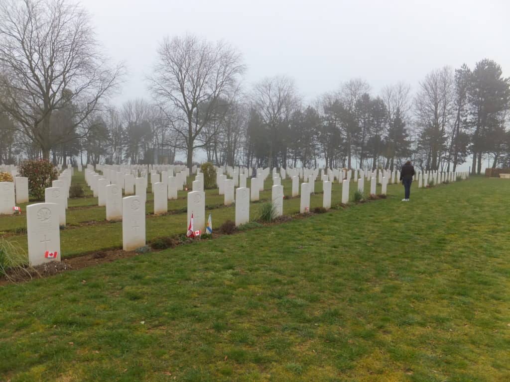 Girl paying respects at grave sites at Canadian War Cemetery in Beny-sur-Mer, France.