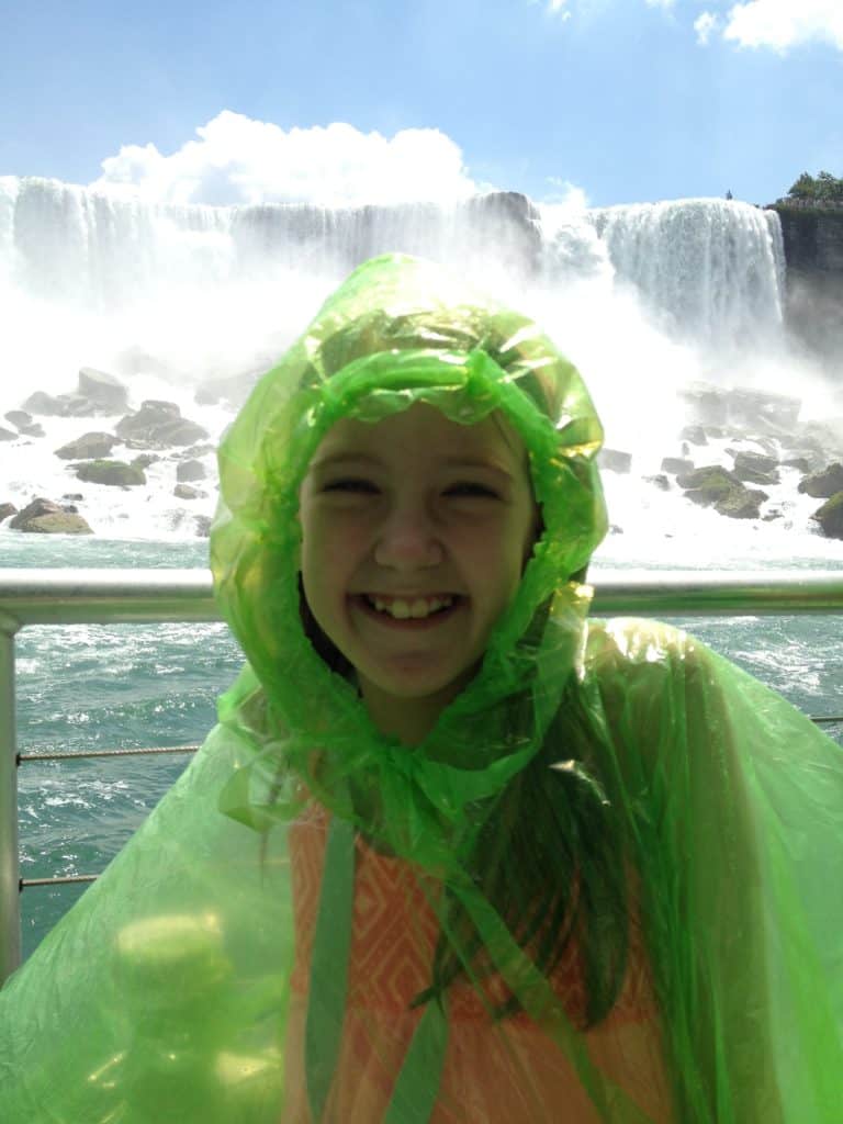 Young girl wearing plastic poncho on Hornblower cruise at base of Niagara Falls, Canada.