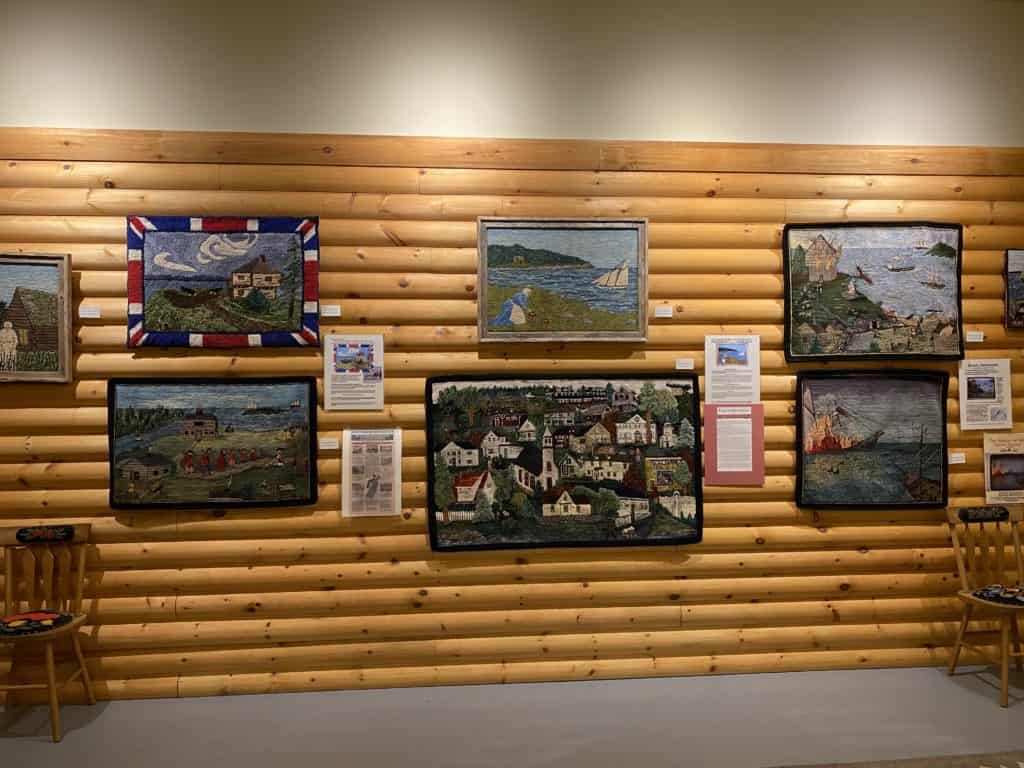 Display of hooked rugs hanging on wall at Hooked Rug Museum of North America, Nova Scotia.