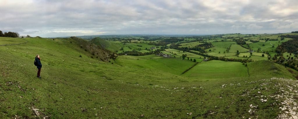 Woman standing in field in Peak District in United Kingdom.