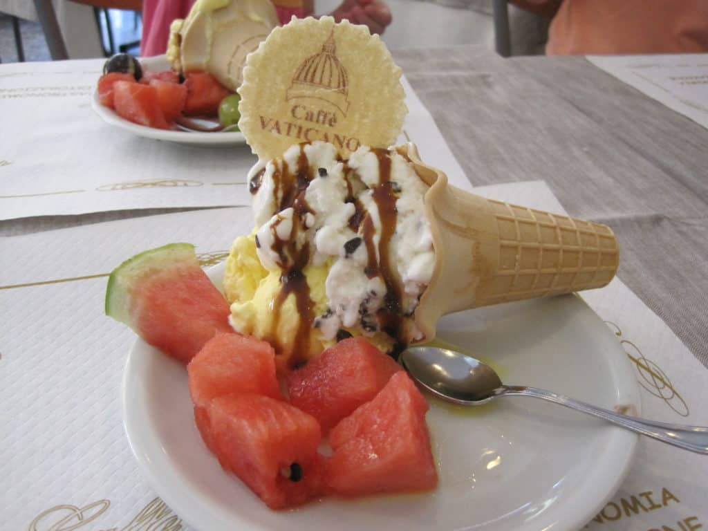 Plate with gelato in a cone and chunks of watermelon at gelato shop near the Vatican.