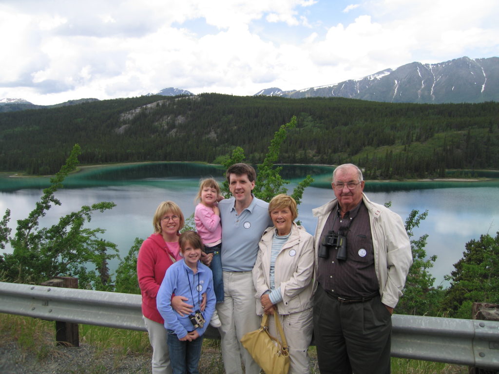 Grandparents, parents and two girls at a glacial lake in Alaska.