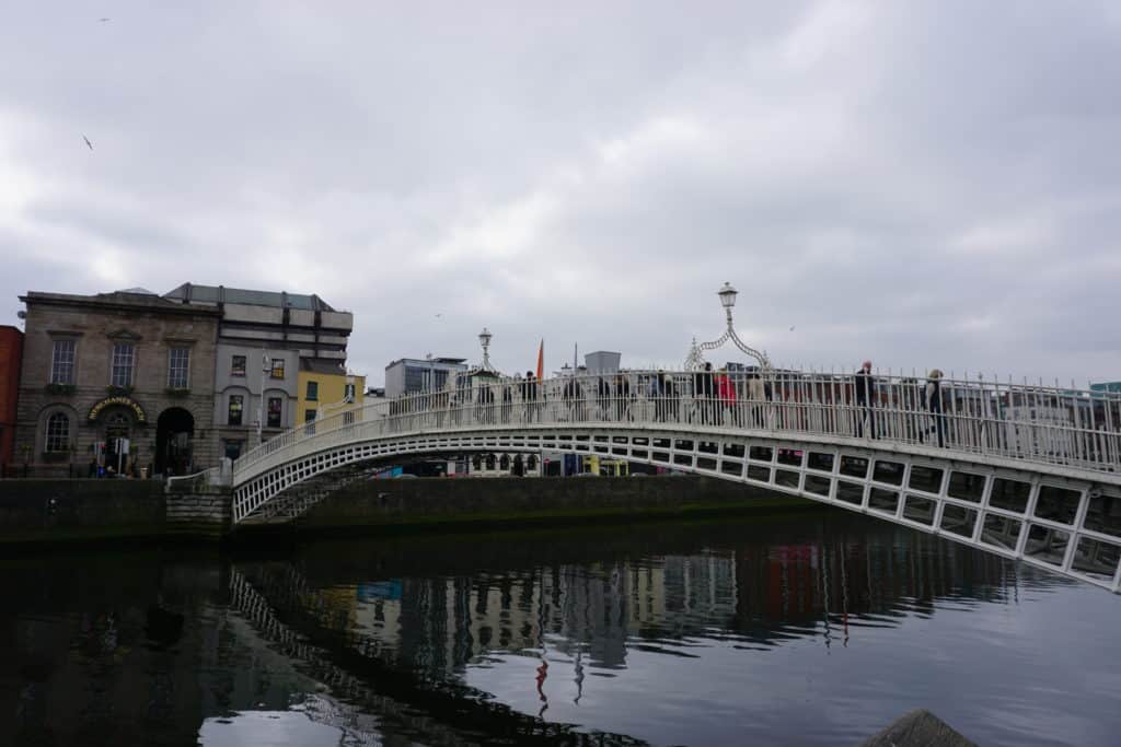 People crossing the Ha'penny Bridge in Dublin, Ireland.
