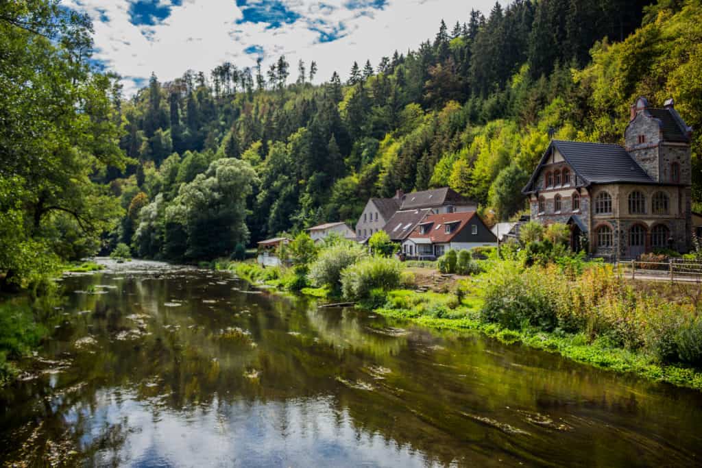 Buildings beside river in Harz Mountains, Germany on sunny autumn day.