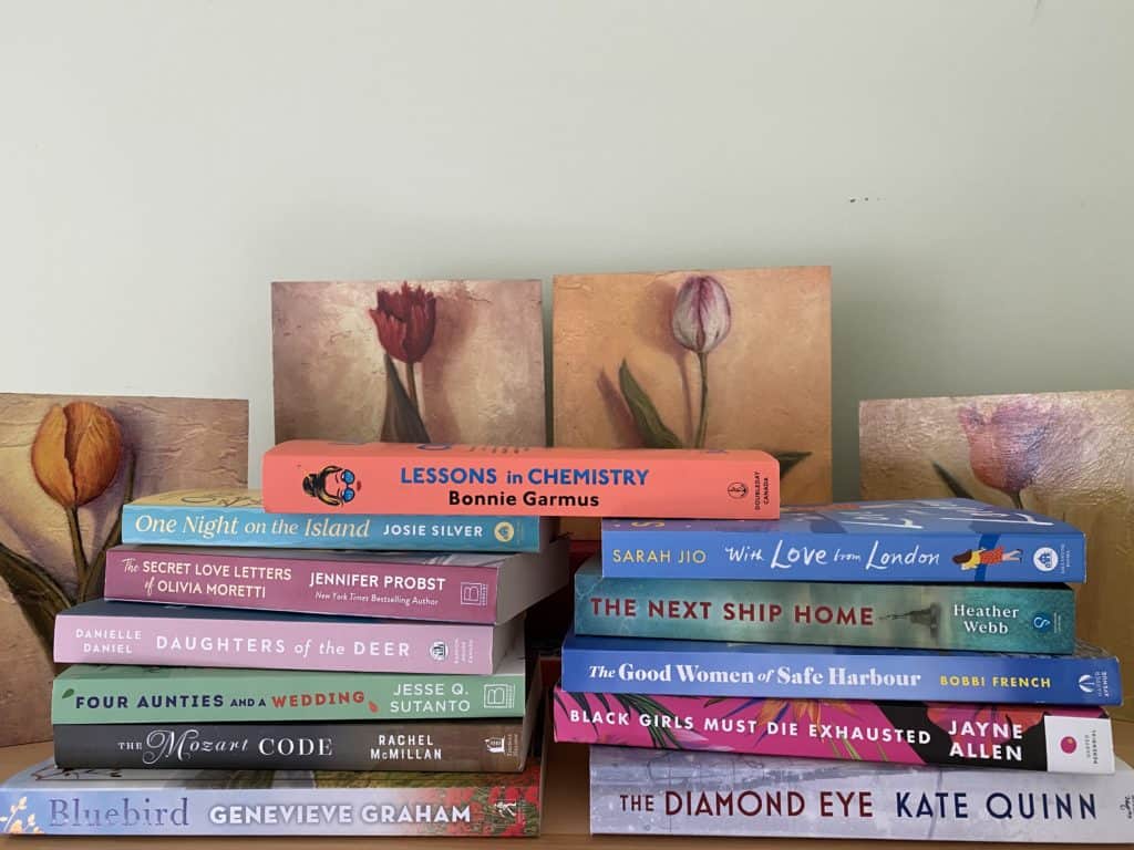 stack of books in front of prints of tulips