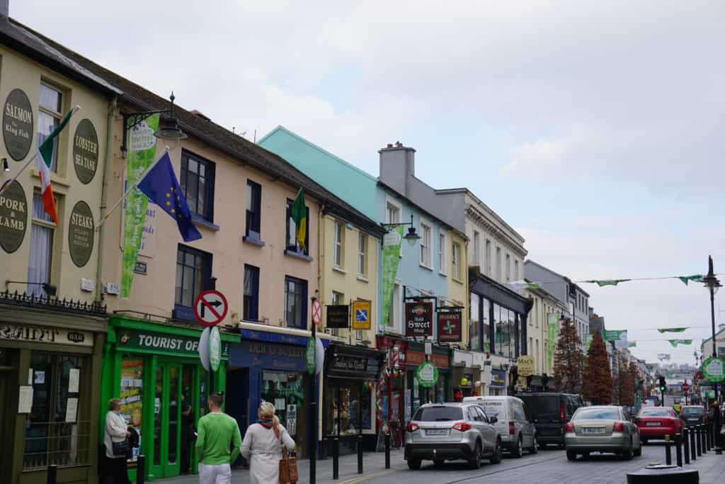 Downtown Killarney street - shops, cars and  a few people on the morning of St. Patrick's Day.