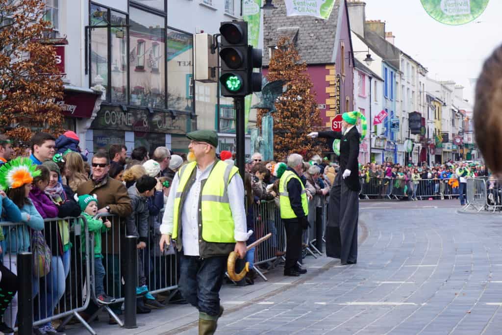 Crowd of people behind barriers waiting for the St. Patrick's Day Parade in downtown Killarney, Ireland.
