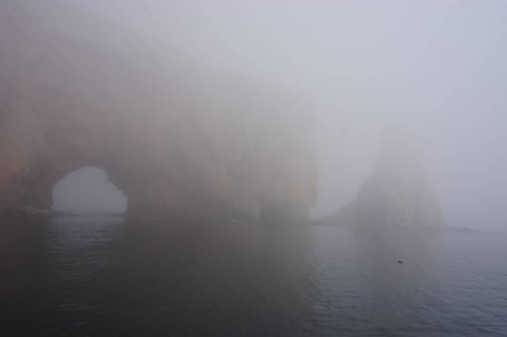 Perce Rock arch from boat in heavy fog.