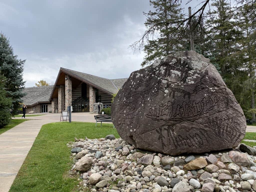 Large engraved stone with McMichael Gallery in background.