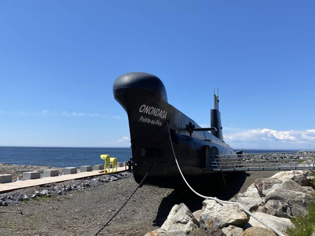 Onondaga submarine sitting on land with St. Lawrence River in background at Point-au-Pere historic site in Rimouski, Quebec.