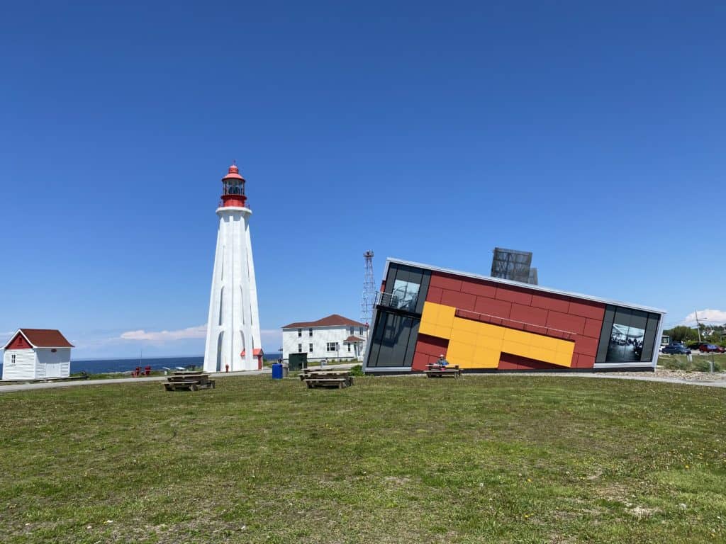 Point-au-Pere Maritime Historic Site in Rimouski, Quebec - white lighthouse with red light and outer buildings alongside Empress of Ireland museum.