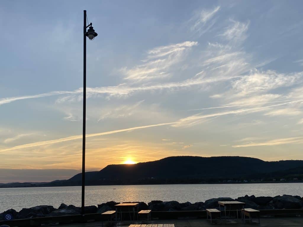 Light standard on pier in Carleton-sur-Mer, Quebec as sun is setting over the water.