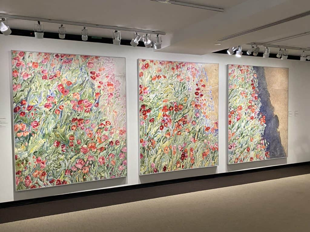 Colourful flowers in three panel painting at McMichael Gallery.