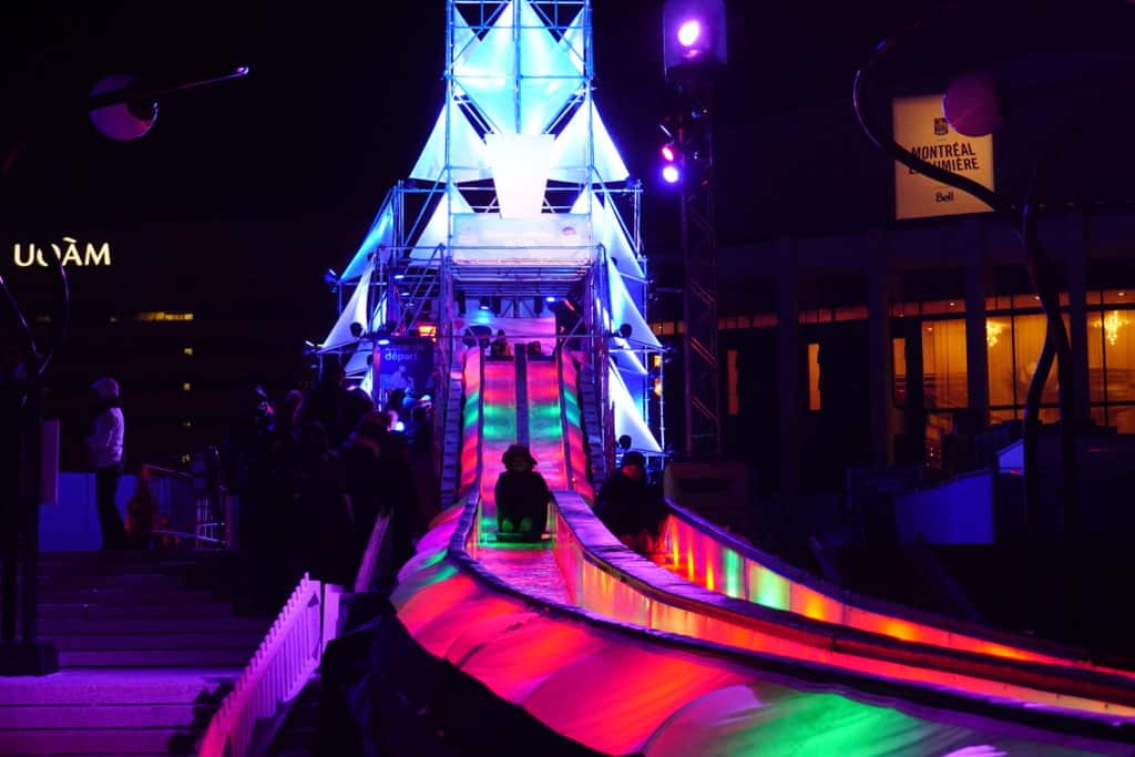 Ice slide lit in bright colours at night at Montreal en Lumiere.