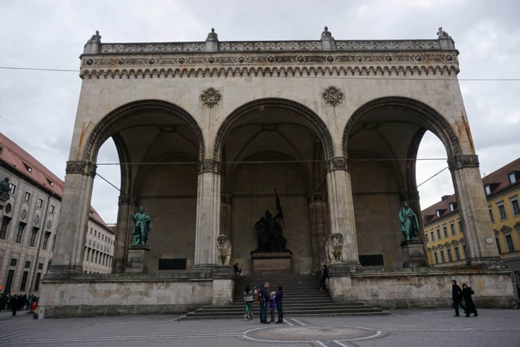People standing in front of Feldherrnhalle on Odeonsplatz in Munich.