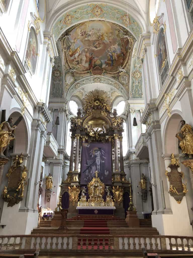 Interior of St. Peter's Church in Munich facing altar at front of church.