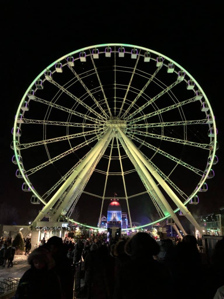 La Grande Roue de Montreal observation wheel lit up at night.