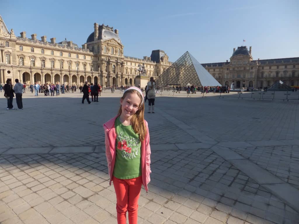 Young girl standing outside the Louvre in Paris, France.