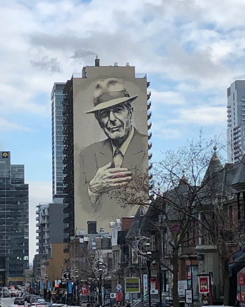 Leonard Cohen mural on side of large building in Montreal.