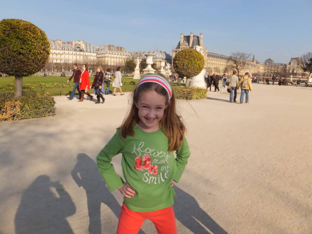 Young girl posing in Tuileries Gardens in Paris, France on a bright spring day.