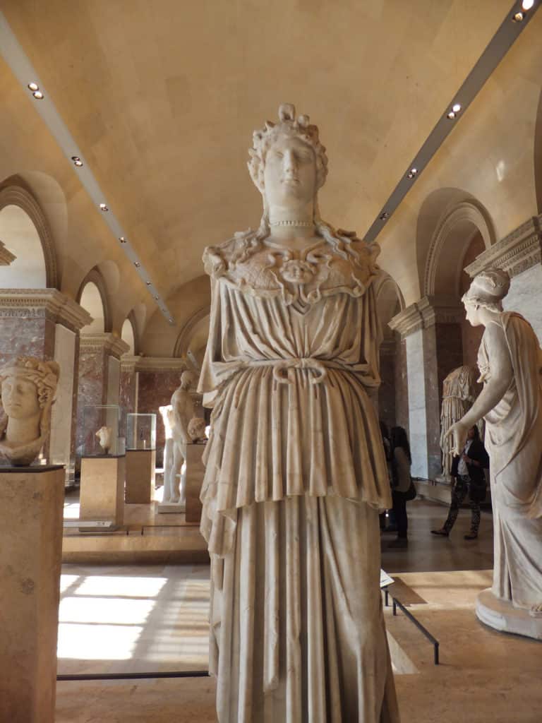 Room filled with sculptures at the Louvre in Paris, France.