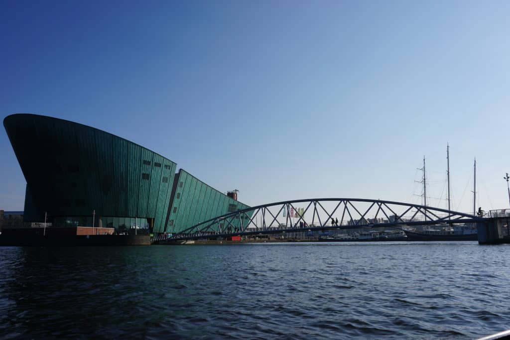 View from water of bridge and Science Centre building in Amsterdam.