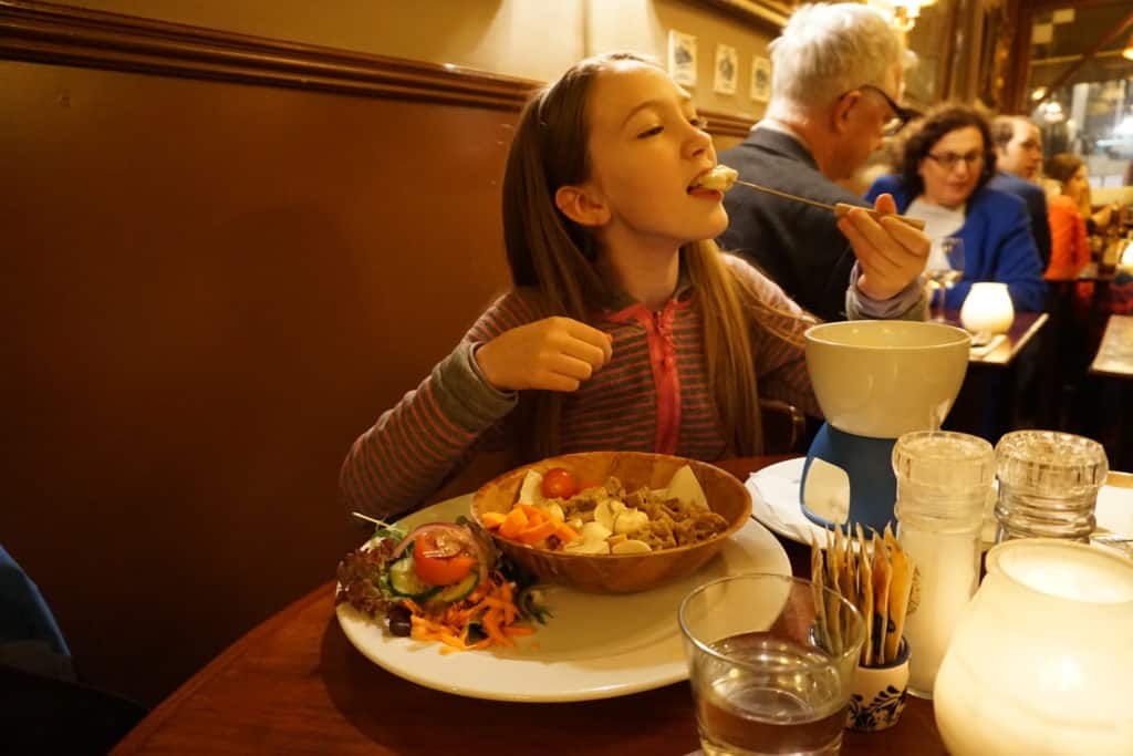 Young girl eating fondue at The Pantry restaurant in Amsterdam.