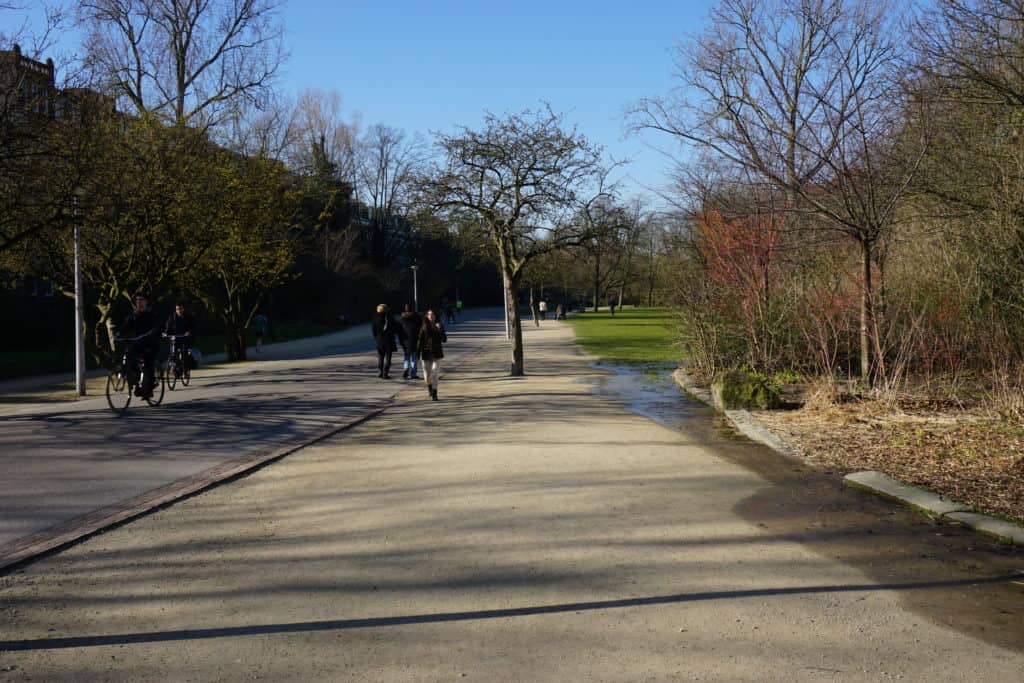 People walking and cycling on a spring day in Vondelpark in Amsterdam.