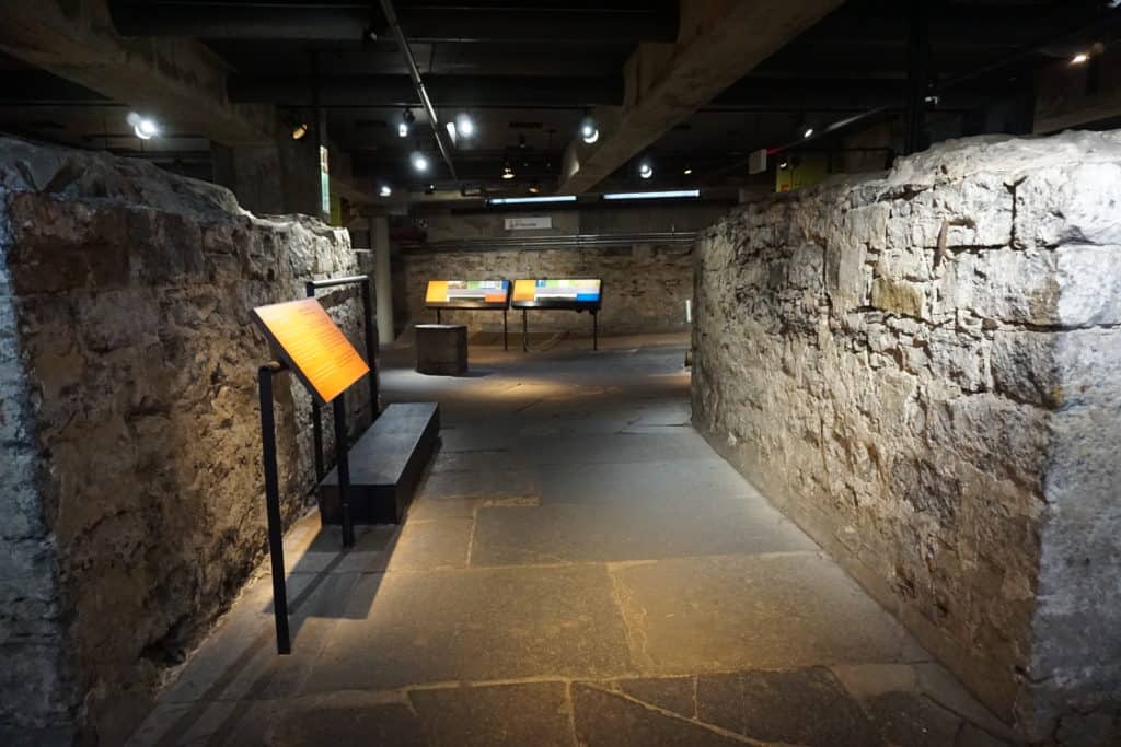 Crossroads Montreal underground exhibit with stone walls of old city at Pointe-à-Callière museum.