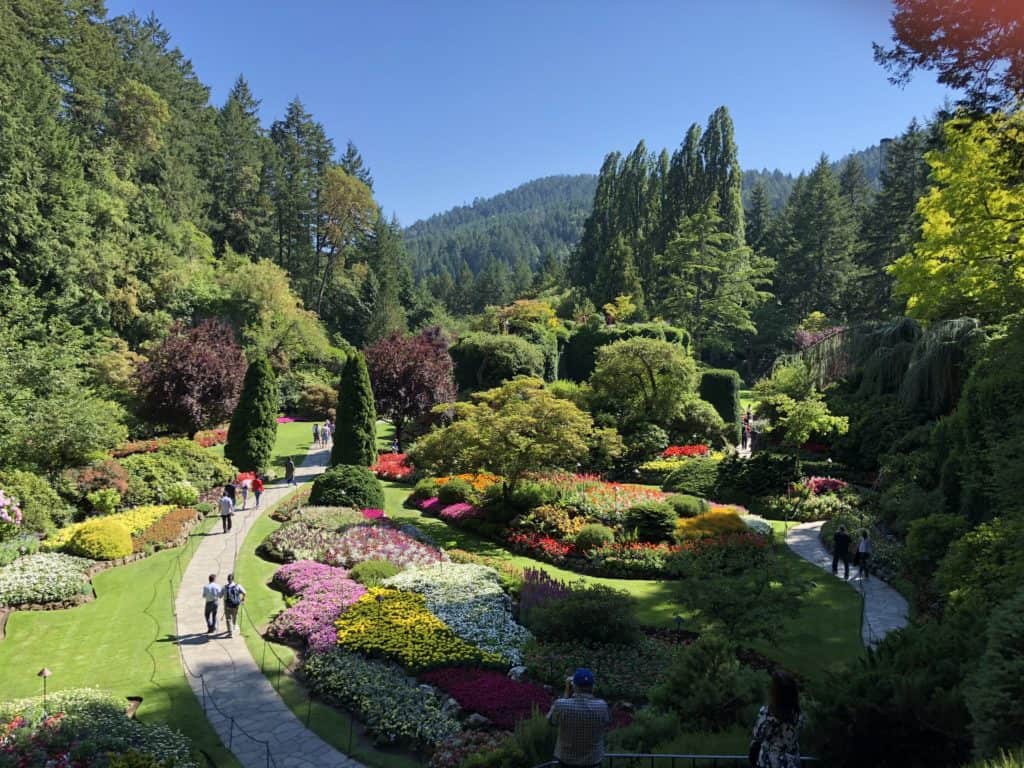 People walking on pathways in The Sunken Garden at The Butchart Gardens in Victoria, British Columbia.