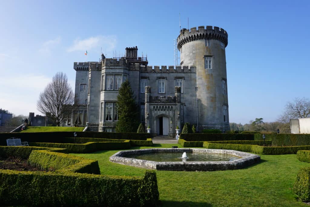 Exterior of Dromoland Castle with formal garden and small fountain.
