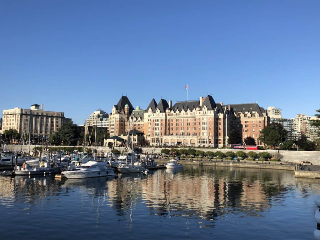 Victoria, British Columbia harbour with boats, Fairmont Empress hotel and reflection in water.