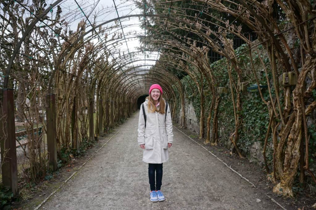 teen girl standing in vine tunnel at Mirabell Gardens in Salzburg, Austria.