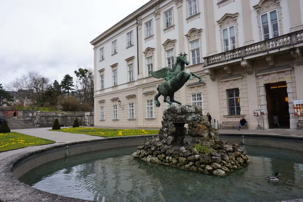 Pegasus statue in fountain at Mirabell Gardens alongside palace.