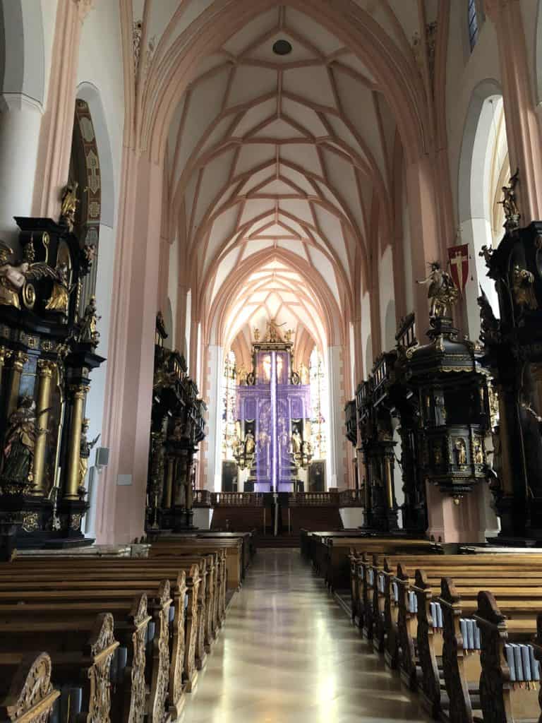 Interior of Mondsee Cathedral looking up aisle to altar at front.