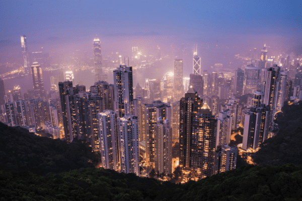 View of Hong Kong at night from Victoria Peak with lighted buildings.