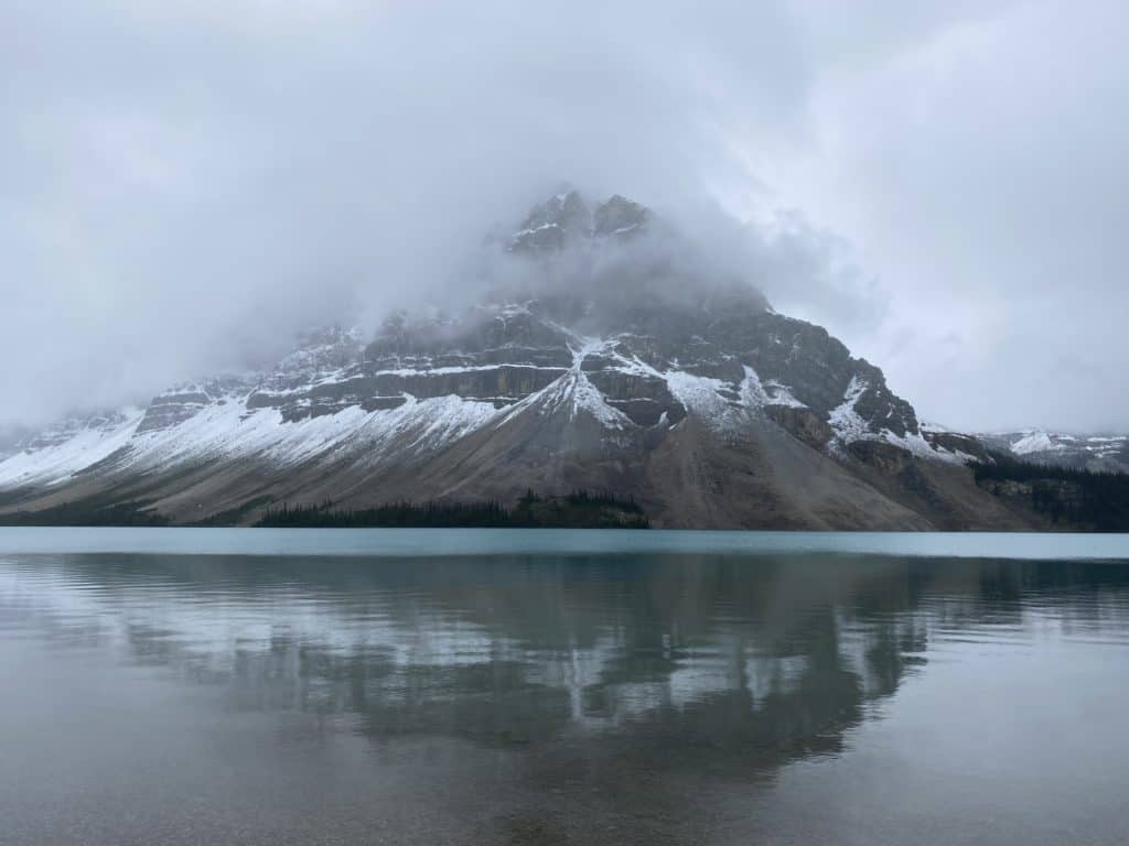 Bow Lake on Icefields Parkway - snow topped mountain reflected in water.