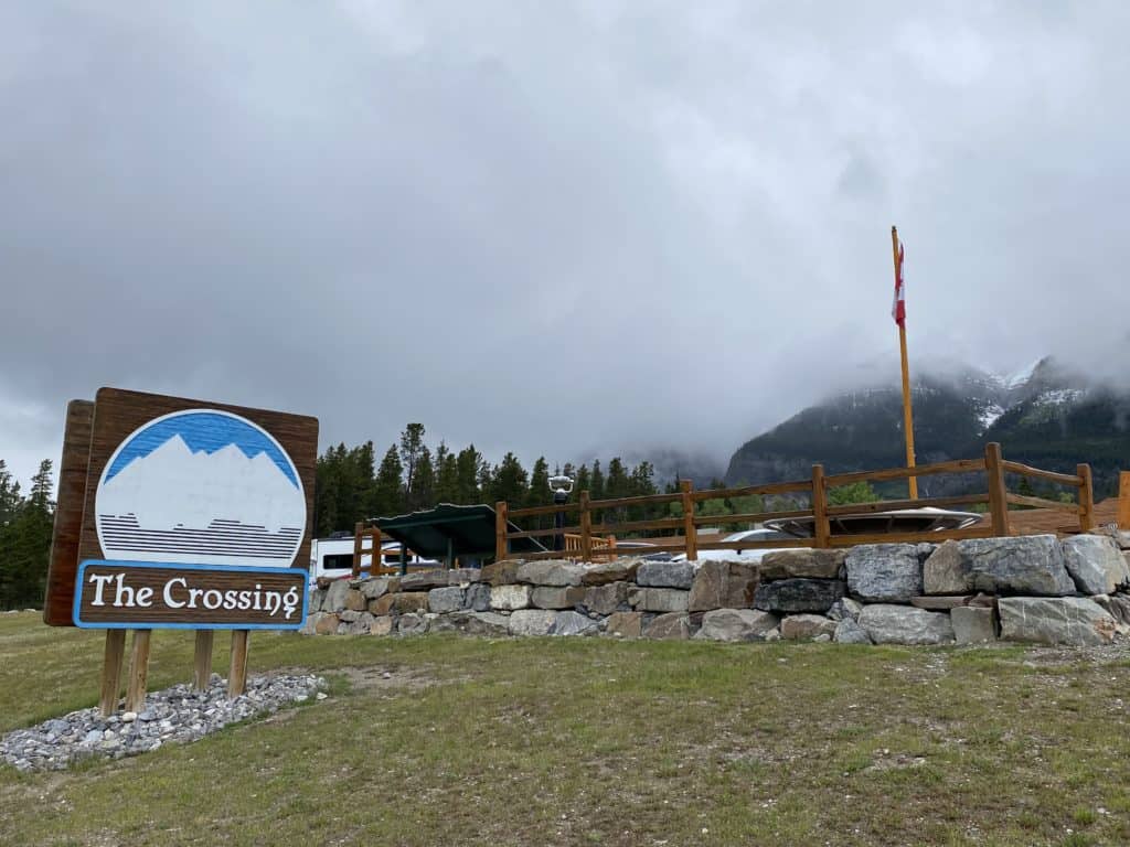 Saskatchewan River Crossing on Icefields Parkway - sign reading The Crossing - fog-covered mountains in background.