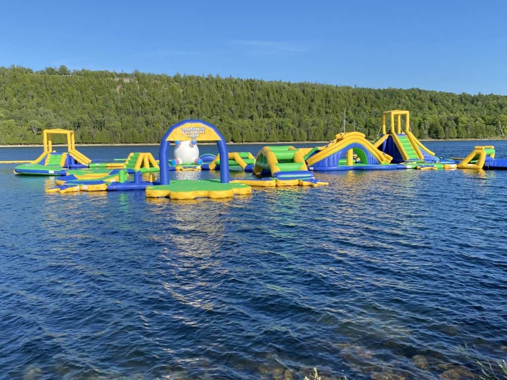 Green, blue, and yellow inflatable water park in lake at Gore Bay.